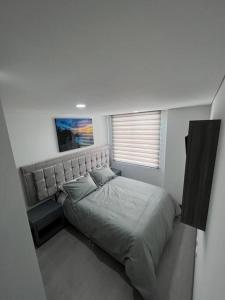 una camera con un letto in una piccola stanza di Edificio Apartamentos central con ascensor 605 a Bogotá