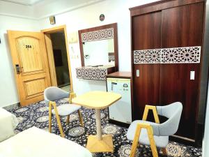 a kitchen with a table and chairs in a room at راحة الوفود الفندقيه in Al Khansāk