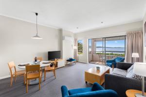 a living room with a couch and a table and chairs at Lorne beach views at the cumberland in Lorne