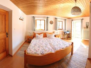 a bedroom with a large bed with a wooden ceiling at Bauernhof Hamberger Hof in Sachrang