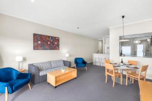 a living room with a couch and a table and chairs at Lorne beach views at the cumberland in Lorne