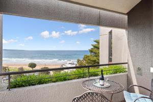 a balcony with a table and a view of the beach at Lorne beach views at the cumberland in Lorne