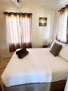 een slaapkamer met een groot wit bed en gordijnen bij Sunset Beach Holiday Park in Geraldton