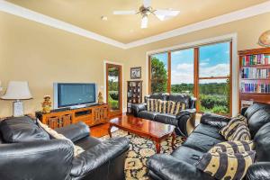 a living room with leather furniture and a flat screen tv at The Ballabourneen Estate in Lovedale