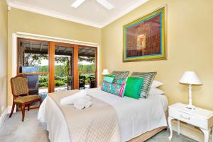 a bedroom with a bed and a chair and a window at The Ballabourneen Estate in Lovedale
