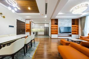 a living room with orange chairs and a dining room at Five Star Westlake 1st-4th Floors Hotel & Serviced Apartment in Hanoi