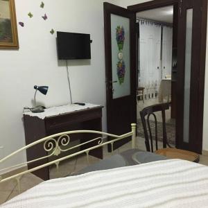 Dormitorio con cama, escritorio y TV en B&B Ciritorno en Vittoria