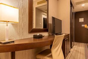 a hotel room with a desk and a mirror at Hotel Sunroute Plaza Shinjuku in Tokyo