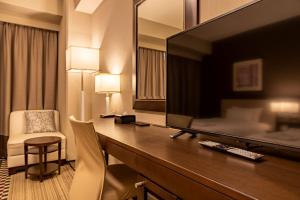 a hotel room with a large flat screen tv at Hotel Sunroute Plaza Shinjuku in Tokyo