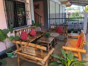un patio con bancos de madera, mesas y plantas en D&D Travellers INN en Puerto Princesa