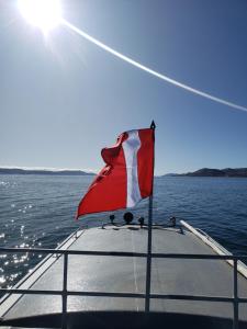 a flag on the front of a boat on the water at Paqariy lodge in Ocosuyo
