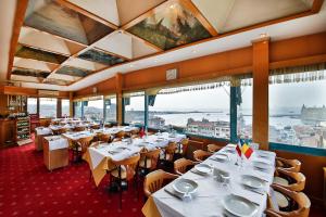 ein Restaurant mit weißen Tischen und Stühlen und Fenstern in der Unterkunft Sidonya Hotel in Istanbul