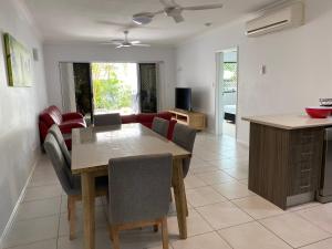 a kitchen and living room with a table and chairs at Trinity Cove Apartments in Trinity Beach