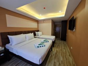 a hotel room with two beds and a tv at Red Coco Inn de Boracay in Boracay