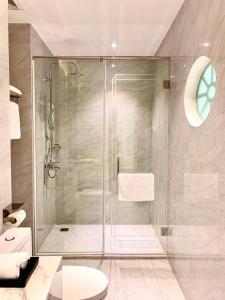 a bathroom with a glass shower with a toilet at Khách sạn LAVENDER - Vincom Tây Ninh in Tây Ninh