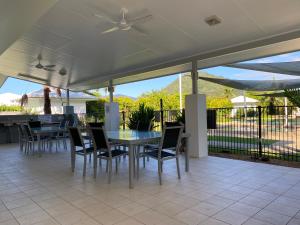 a patio with a table and chairs and a ceiling fan at Trinity Cove Apartments in Trinity Beach
