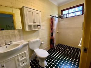 a bathroom with a white toilet and a sink at Battunga Cottages in Watervale