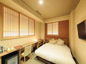 1 dormitorio con cama, escritorio y ordenador en HOTEL CUORE Kyoto Shijo Omiya en Kioto