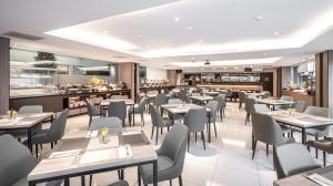 竹北市にあるHotel Bonzaのテーブルと椅子とバーのあるレストラン