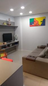 sala de estar con cama y TV en Aconchegante apartamento em Itapema 300 mts praia, en Itapema