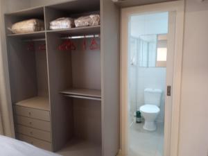 baño con vestidor y aseo en Aconchegante apartamento em Itapema 300 mts praia, en Itapema