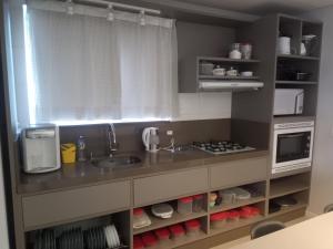 cocina con fregadero y microondas en Aconchegante apartamento em Itapema 300 mts praia, en Itapema