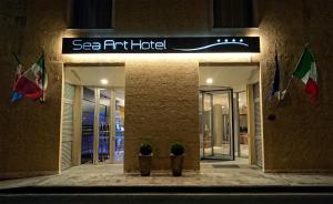 瓦多利古雷的住宿－Sea Art Hotel，前面有两株盆栽植物的建筑