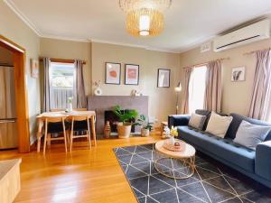 uma sala de estar com um sofá azul e uma mesa em Stunning Hobart 3-bed home- close to shopping centers em Glenorchy
