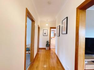 a hallway of a home with white walls and wooden floors at Stunning Hobart 3-bed home- close to shopping centers in Glenorchy