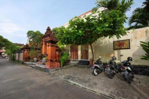 two motorcycles parked in front of a building at Graha Wedha Suite Kuta by kamara in Kuta