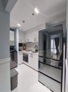 a kitchen with white cabinets and stainless steel appliances at The Florence at McKinley Hill in Manila