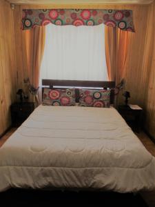 1 dormitorio con 1 cama grande y ventana en ECOHOSTAL HUELLAS DEL BOSQUE, en Valdivia