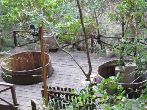 bañera de hidromasaje en una terraza de madera en el bosque en ECOHOSTAL HUELLAS DEL BOSQUE, en Valdivia