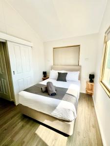 een slaapkamer met een groot wit bed met 2 kussens bij Sunset Beach Holiday Park in Geraldton
