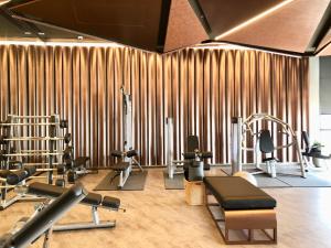 a gym with treadmills and exercise equipment in front of a bamboo wall at Edge Central Pattaya By Alice in Pattaya