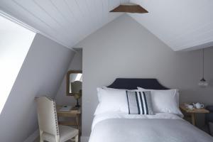 sypialnia z białym łóżkiem i krzesłem w obiekcie Albion House at Ramsgate w mieście Ramsgate