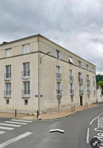 un grand bâtiment blanc sur le côté d'une rue dans l'établissement Appartement avec vue sur la tour de Vésone, à Périgueux