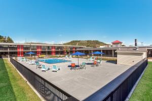 a pool with chairs and umbrellas on a patio at Econo Lodge in Cave City