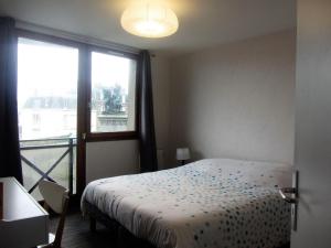 1 dormitorio con cama y ventana grande en Appartement Granville, 3 pièces, 4 personnes - FR-1-361-123, en Granville