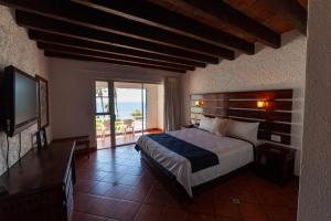 Postel nebo postele na pokoji v ubytování Las Rocas Resort & Spa