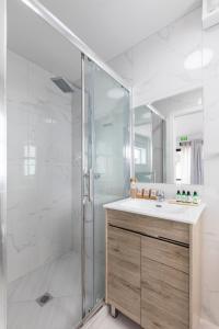 Un baño blanco con ducha y lavabo. en Solsen Flexi-Stay, en Auckland