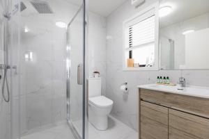 a bathroom with a shower and a toilet and a sink at Solsen Flexi-Stay in Auckland