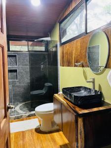 a bathroom with a toilet and a glass shower at Cabañas La Montaña Mountain Lodge in Monteverde Costa Rica