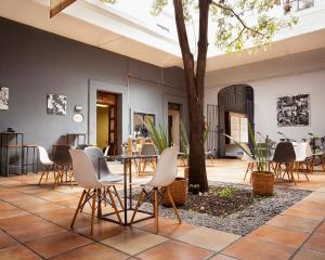 a patio with a table and chairs and a tree at BKL Hotel in Oaxaca City