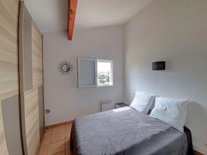 1 dormitorio con cama y ventana en Maison Saintes-Maries-de-la-Mer, 3 pièces, 4 personnes - FR-1-475-91 en Saintes-Maries-de-la-Mer