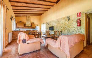 sala de estar con sillas y pared de piedra. en Cozy Home In Caravaca De La Cruz With Kitchen, en Caravaca de la Cruz