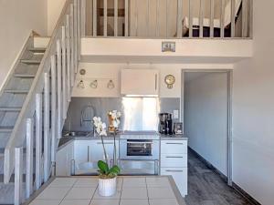 a kitchen with white cabinets and a staircase at Appartement Saintes-Maries-de-la-Mer, 3 pièces, 4 personnes - FR-1-475-83 in Saintes-Maries-de-la-Mer