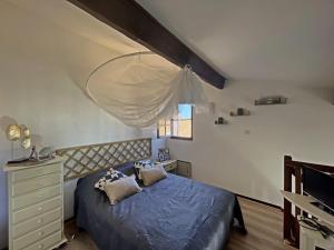a bedroom with a bed and a dresser and a window at Appartement Saintes-Maries-de-la-Mer, 2 pièces, 4 personnes - FR-1-475-84 in Saintes-Maries-de-la-Mer