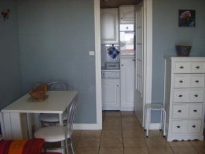 een keuken met een tafel, stoelen en een aanrecht bij Appartement Royan, 2 pièces, 4 personnes - FR-1-494-140 in Royan
