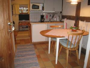 a kitchen with a table and chairs in a room at Mariehem Logi in Sjöbo